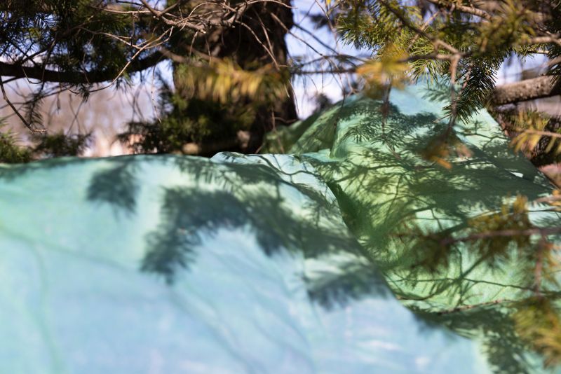 Detailaufnahme des Baumwollstoffs in einem Baum. Die Schatten fallen auf das Tuch.